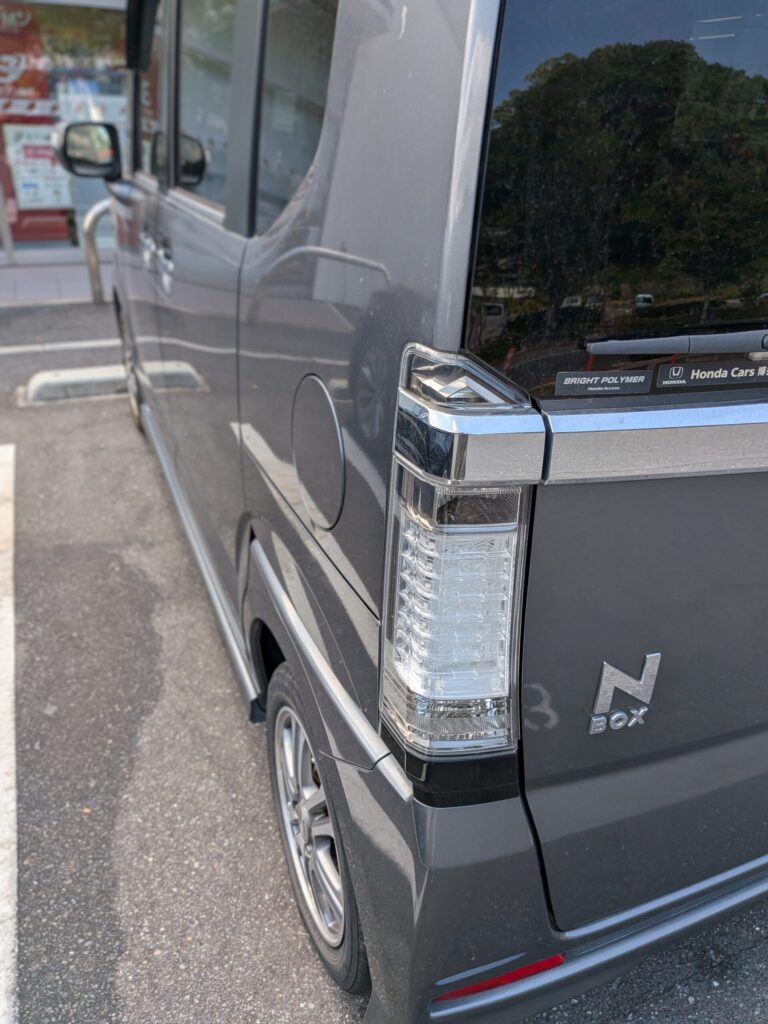 グレーのホンダN-BOXのリアコーナーのクローズアップ。縦型のテールランプとクロームのトリムが見える。 - 車専門鍵店カーロック 施工実績・鍵作成